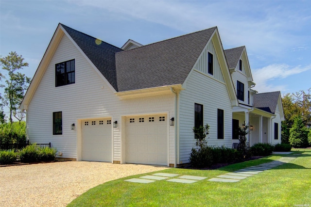 151 Newtown Ln, East Hampton, NY 11937 - view of home's exterior with gravel driveway, a yard, roof with shingles, board and batten siding, and an attached garage