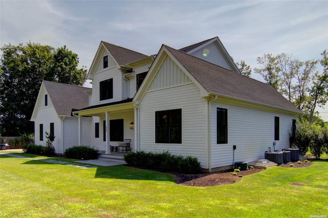 view of front of property with central air condition unit, a porch, and a front yard