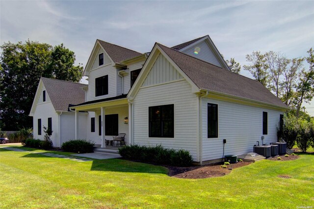 151 Newtown Ln, East Hampton, NY 11937 - view of front of property with covered porch, a front yard, board and batten siding, and roof with shingles