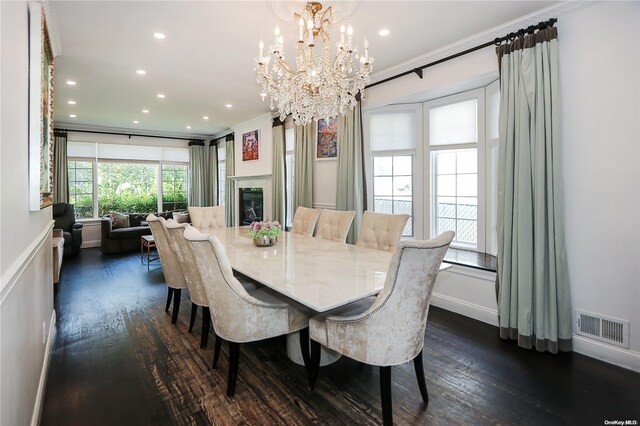 dining area featuring crown molding, dark hardwood / wood-style flooring, and a notable chandelier