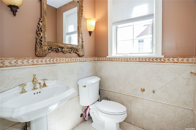 bathroom with plenty of natural light, tile walls, and sink