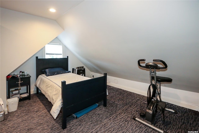 bedroom featuring dark colored carpet and vaulted ceiling