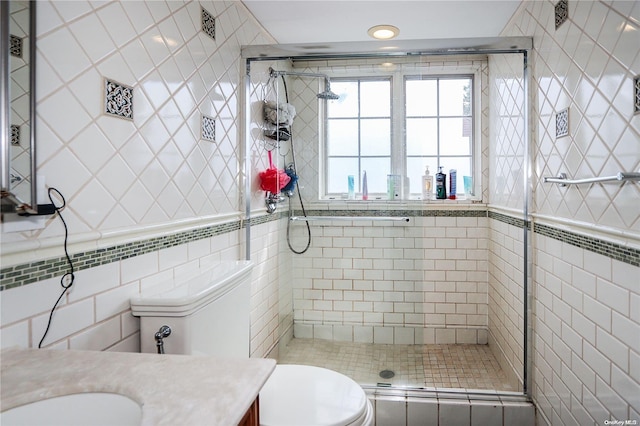 bathroom featuring an enclosed shower, vanity, and tile walls