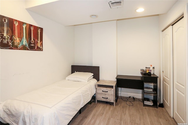 bedroom with light wood-type flooring and a closet