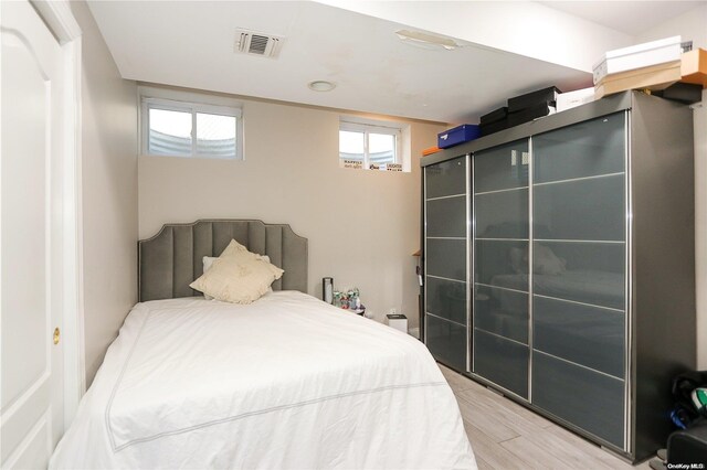 bedroom with wood-type flooring and multiple windows