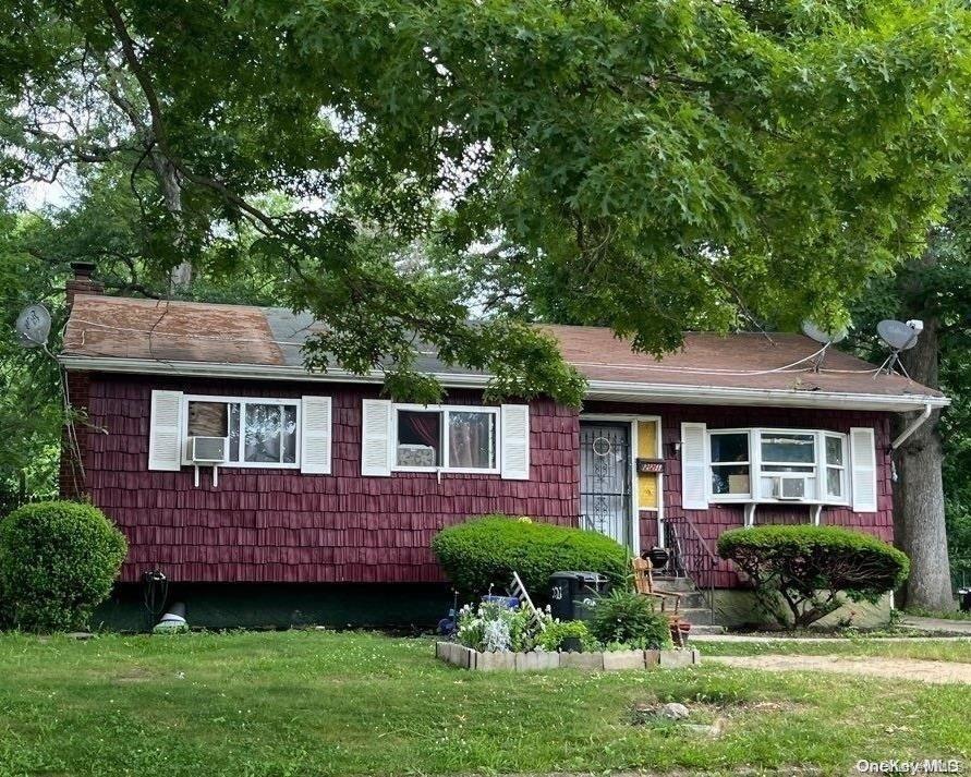 view of front of home featuring a front yard and cooling unit