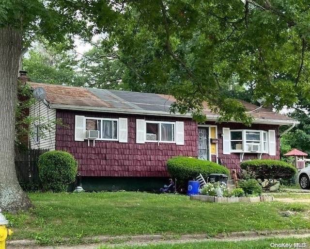 view of front of property featuring a front lawn and cooling unit