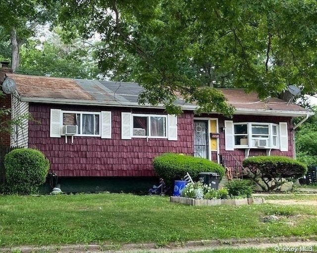 view of front of house featuring cooling unit and a front lawn