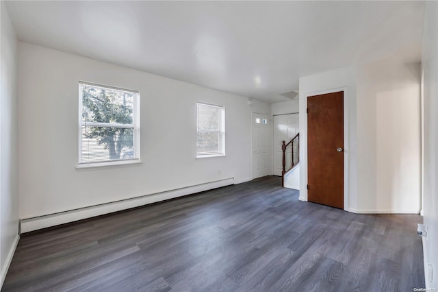 unfurnished room with dark hardwood / wood-style flooring and a baseboard heating unit