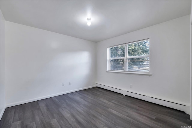 unfurnished room with dark hardwood / wood-style flooring and a baseboard heating unit