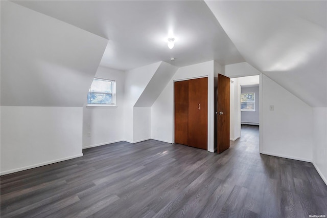 additional living space with dark hardwood / wood-style floors and vaulted ceiling