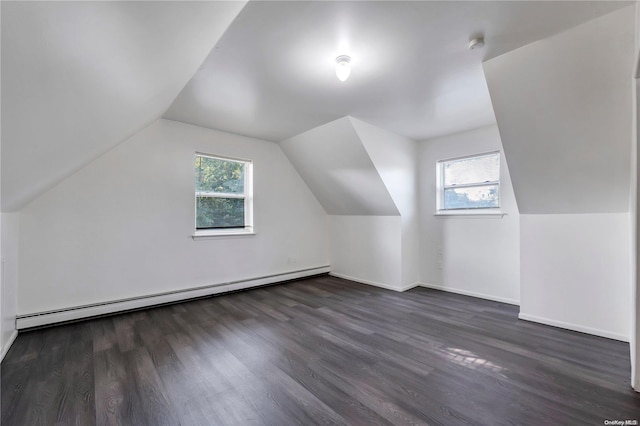 additional living space featuring baseboard heating, a wealth of natural light, dark wood-type flooring, and lofted ceiling