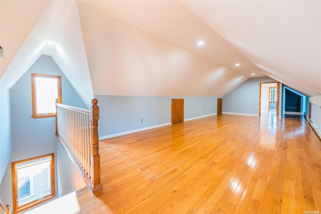 bonus room with light hardwood / wood-style floors and vaulted ceiling