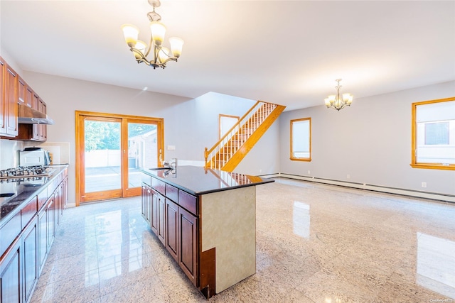 kitchen featuring pendant lighting, a notable chandelier, sink, and a kitchen island with sink