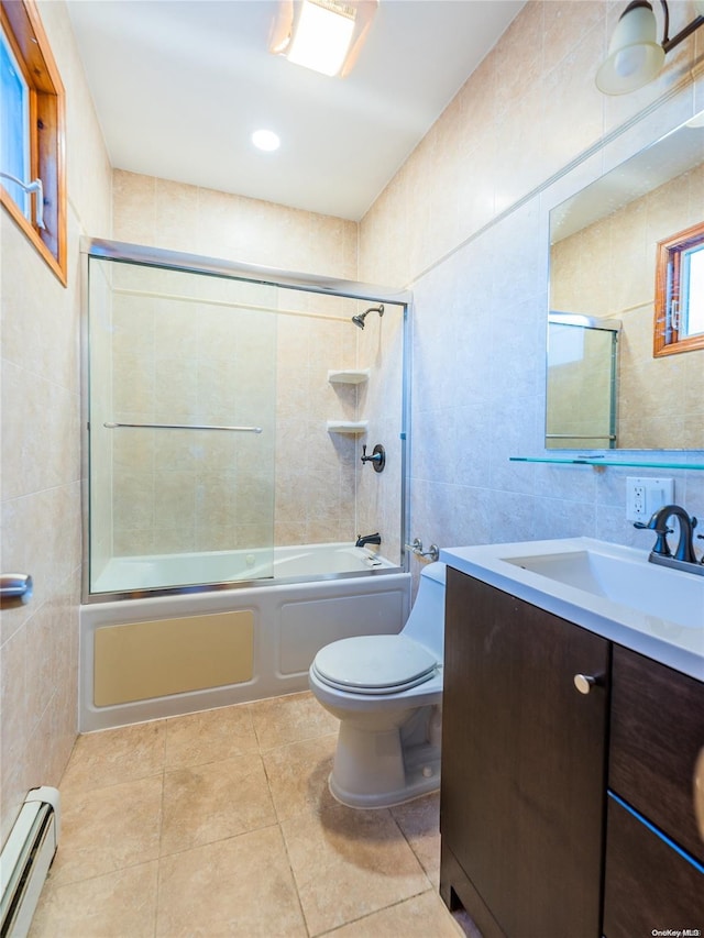 full bathroom featuring vanity, baseboard heating, tile walls, enclosed tub / shower combo, and tile patterned flooring