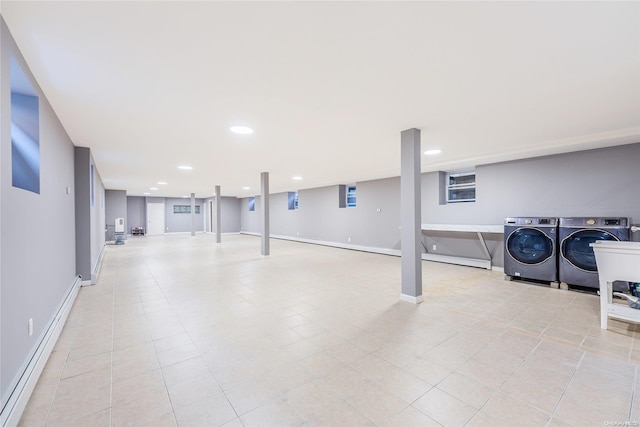 basement featuring independent washer and dryer, baseboard heating, and light tile patterned flooring