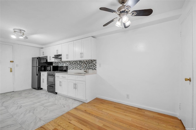 kitchen with backsplash, sink, black appliances, white cabinets, and light hardwood / wood-style floors