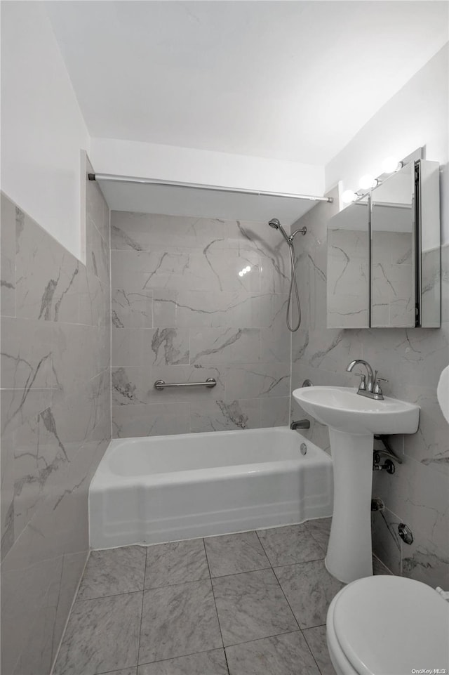 bathroom featuring tile walls, tiled shower / bath combo, and toilet