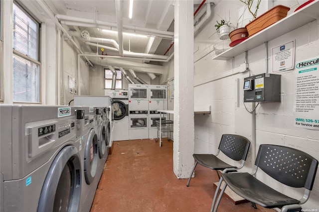 laundry room with a healthy amount of sunlight, washer and dryer, and stacked washer / drying machine