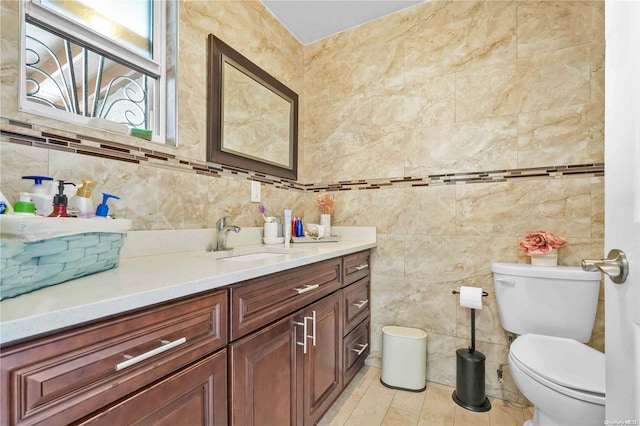 bathroom with vanity, tile walls, and toilet