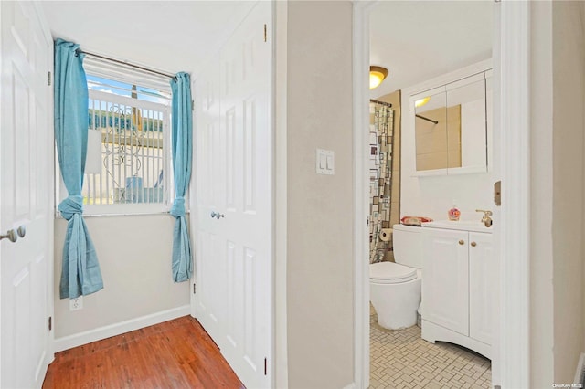 bathroom with curtained shower, vanity, wood-type flooring, and toilet