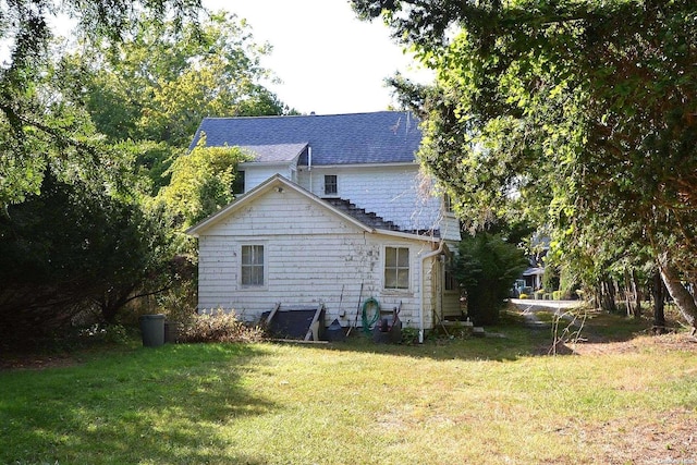 rear view of house featuring a yard