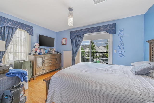 bedroom with access to exterior and hardwood / wood-style flooring