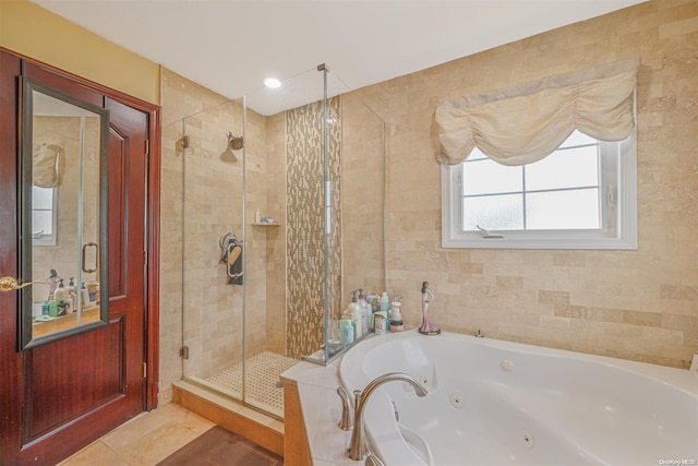 bathroom featuring tile patterned flooring, shower with separate bathtub, and tile walls