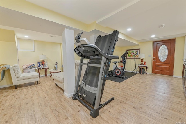 exercise room featuring light wood-type flooring