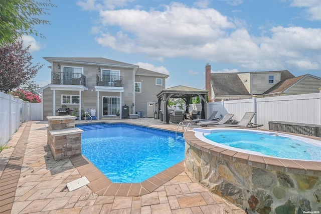 view of pool featuring a gazebo, a patio area, and an in ground hot tub