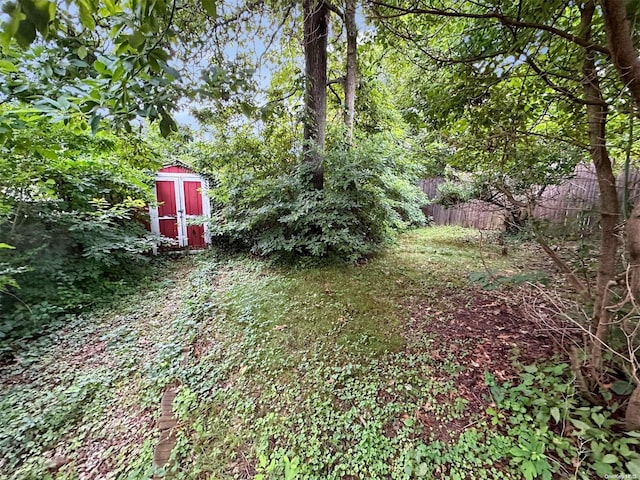 view of yard featuring fence and a storage shed