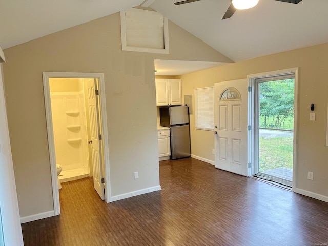 interior space featuring baseboards, vaulted ceiling, and dark wood-style flooring