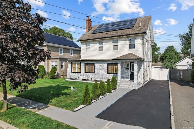 view of front facade with solar panels and a front lawn