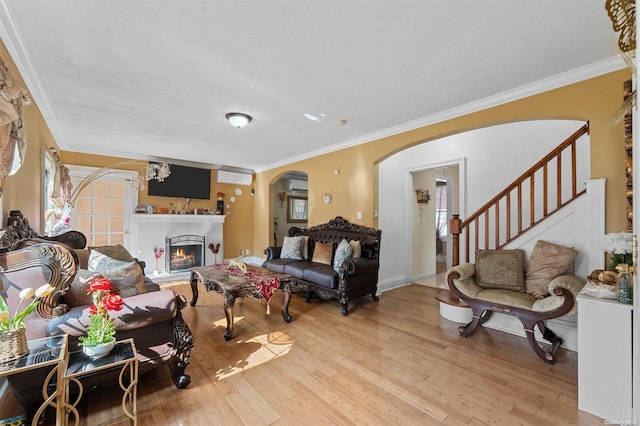 living room with crown molding, light hardwood / wood-style flooring, and a chandelier