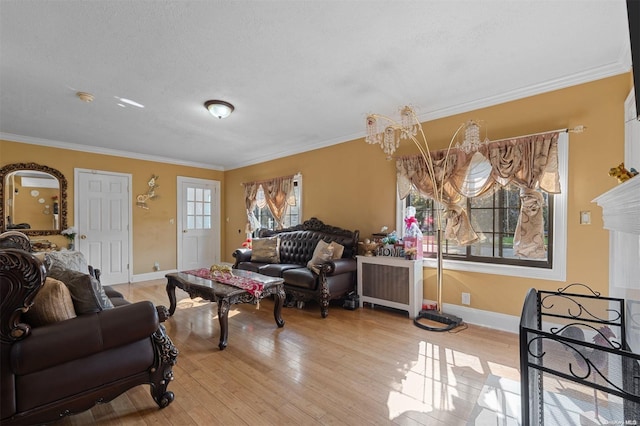 living room with a healthy amount of sunlight, light hardwood / wood-style floors, and crown molding