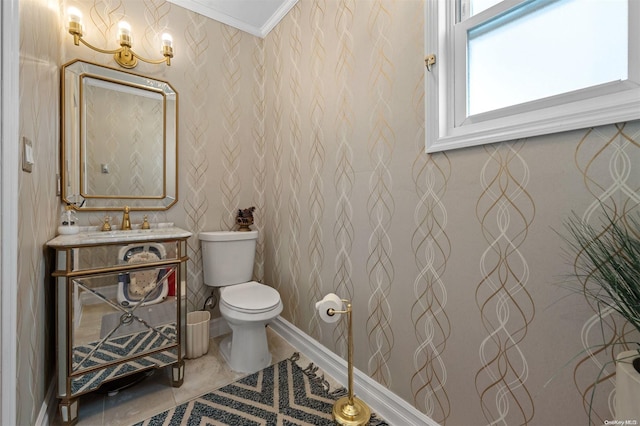 bathroom featuring toilet, ornamental molding, and sink