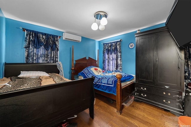 bedroom featuring wood-type flooring and a wall unit AC