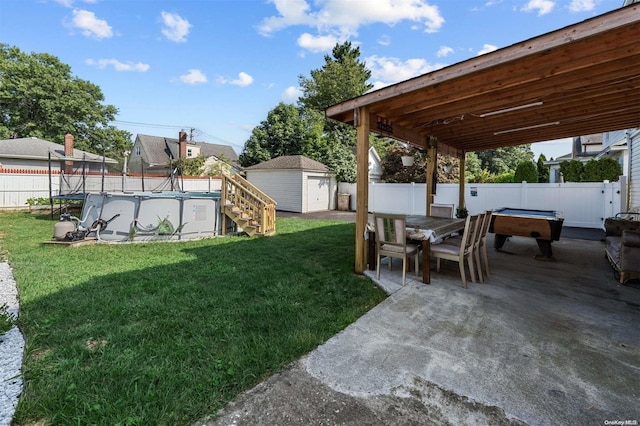 view of yard featuring a fenced in pool, a patio, and a shed