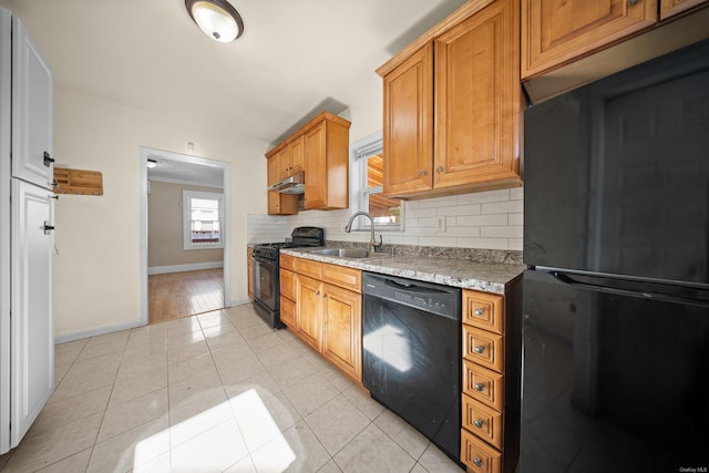 kitchen with light tile patterned floors, backsplash, a sink, under cabinet range hood, and black appliances