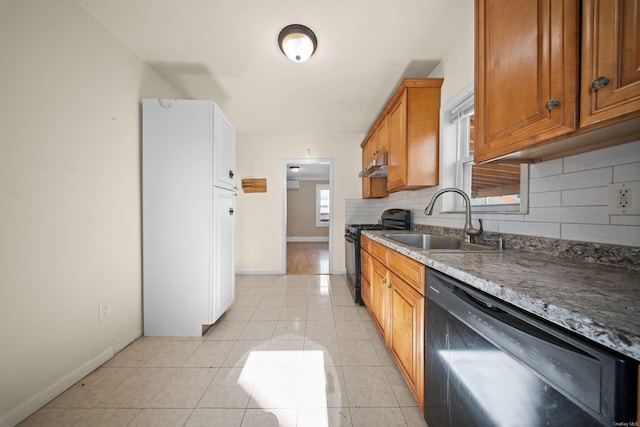 kitchen featuring brown cabinetry, a sink, under cabinet range hood, black appliances, and backsplash