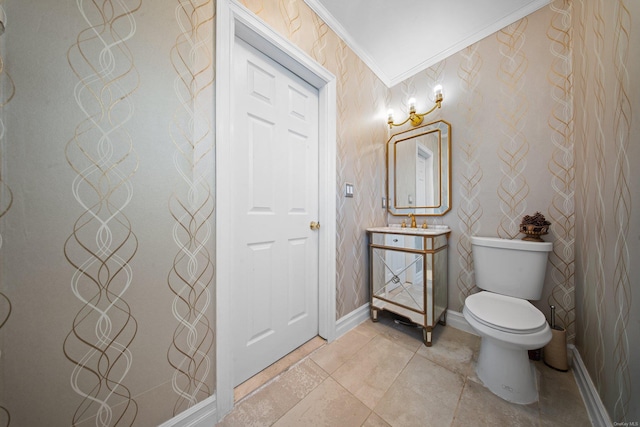 bathroom featuring baseboards, vanity, toilet, and crown molding