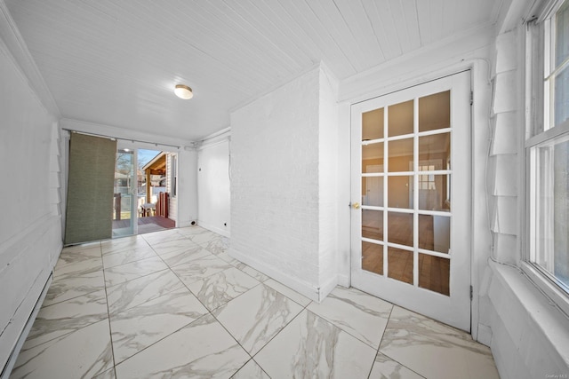 empty room featuring marble finish floor and ornamental molding