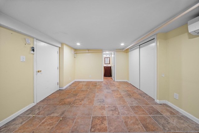 finished basement featuring an AC wall unit, recessed lighting, and baseboards