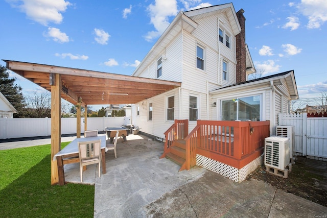 back of property with fence private yard, a yard, a chimney, and a wooden deck