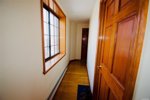 hallway with dark hardwood / wood-style floors and baseboard heating