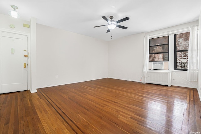 unfurnished room with hardwood / wood-style floors, ceiling fan, and radiator