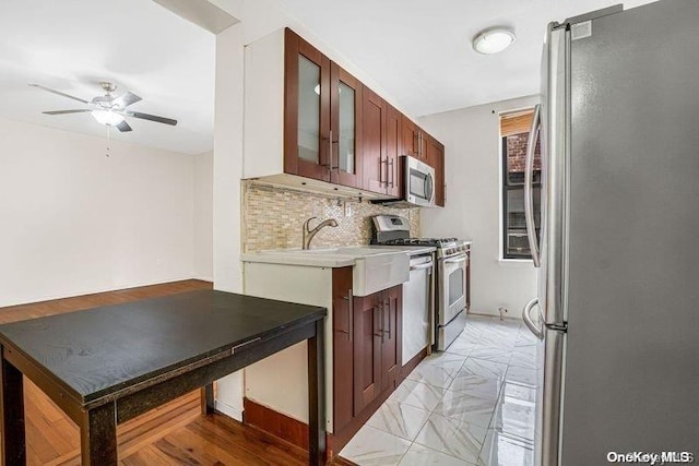 kitchen with ceiling fan, sink, appliances with stainless steel finishes, and tasteful backsplash