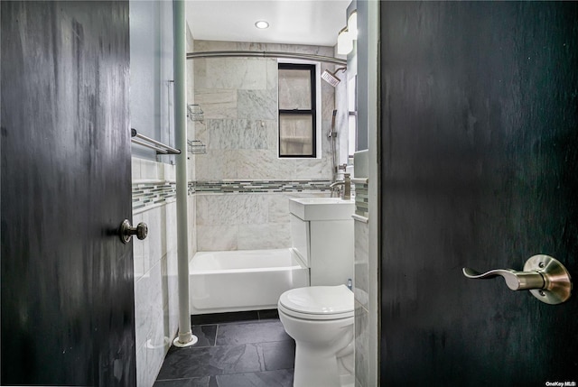 full bathroom featuring vanity, tiled shower / bath combo, and toilet