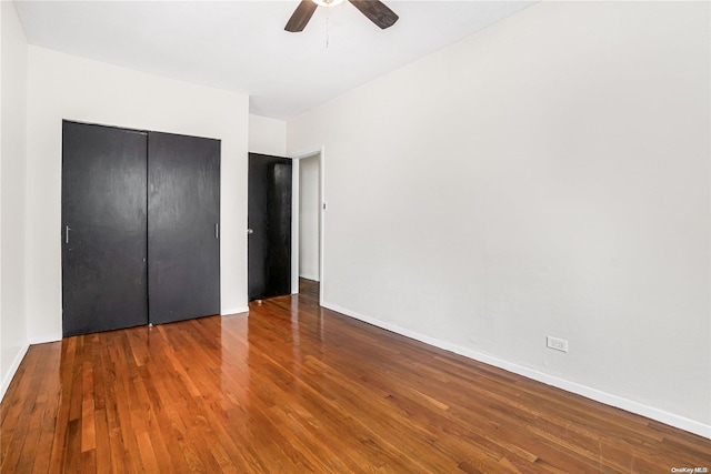 unfurnished bedroom featuring wood-type flooring, a closet, and ceiling fan