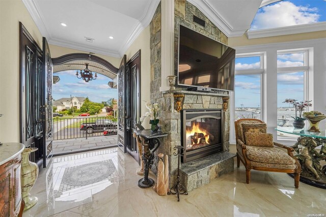 entryway with a stone fireplace and crown molding